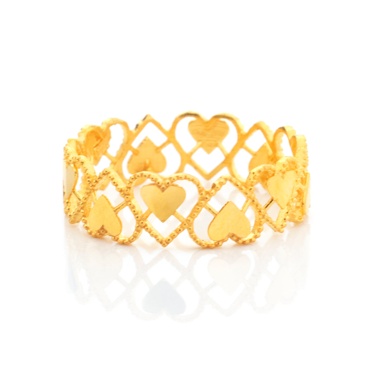 A gold heart-link ring with a textured trellis pattern and polished heart cutouts, displayed on a clean white background with a soft reflection.