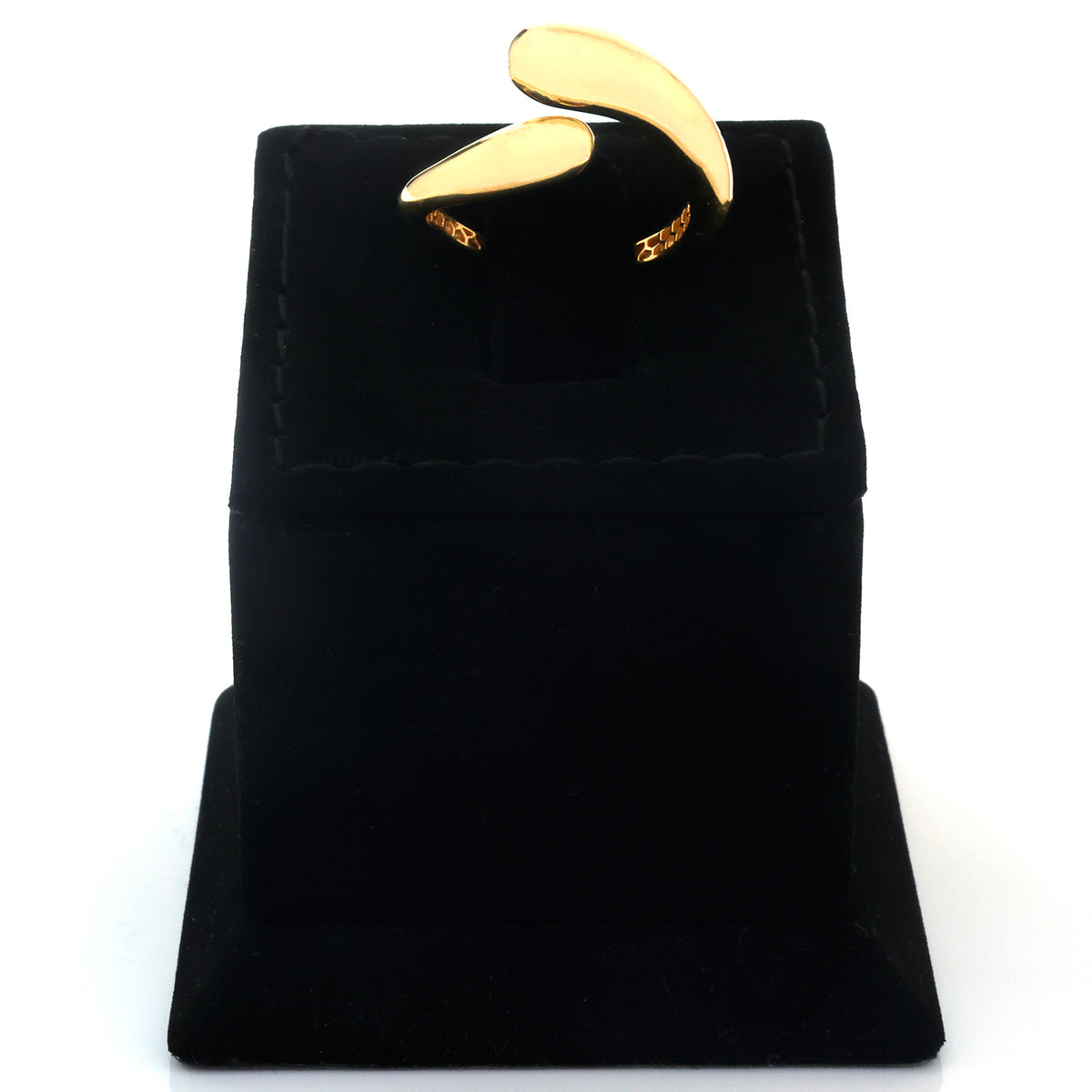 A gold ring with a curved, wing-like design displayed on a black velvet ring box against a white background.