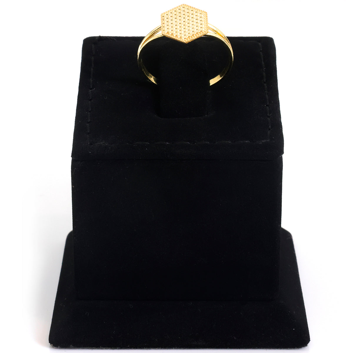 A gold ring with a textured hexagonal top, displayed on a black velvet ring box against a white background.
