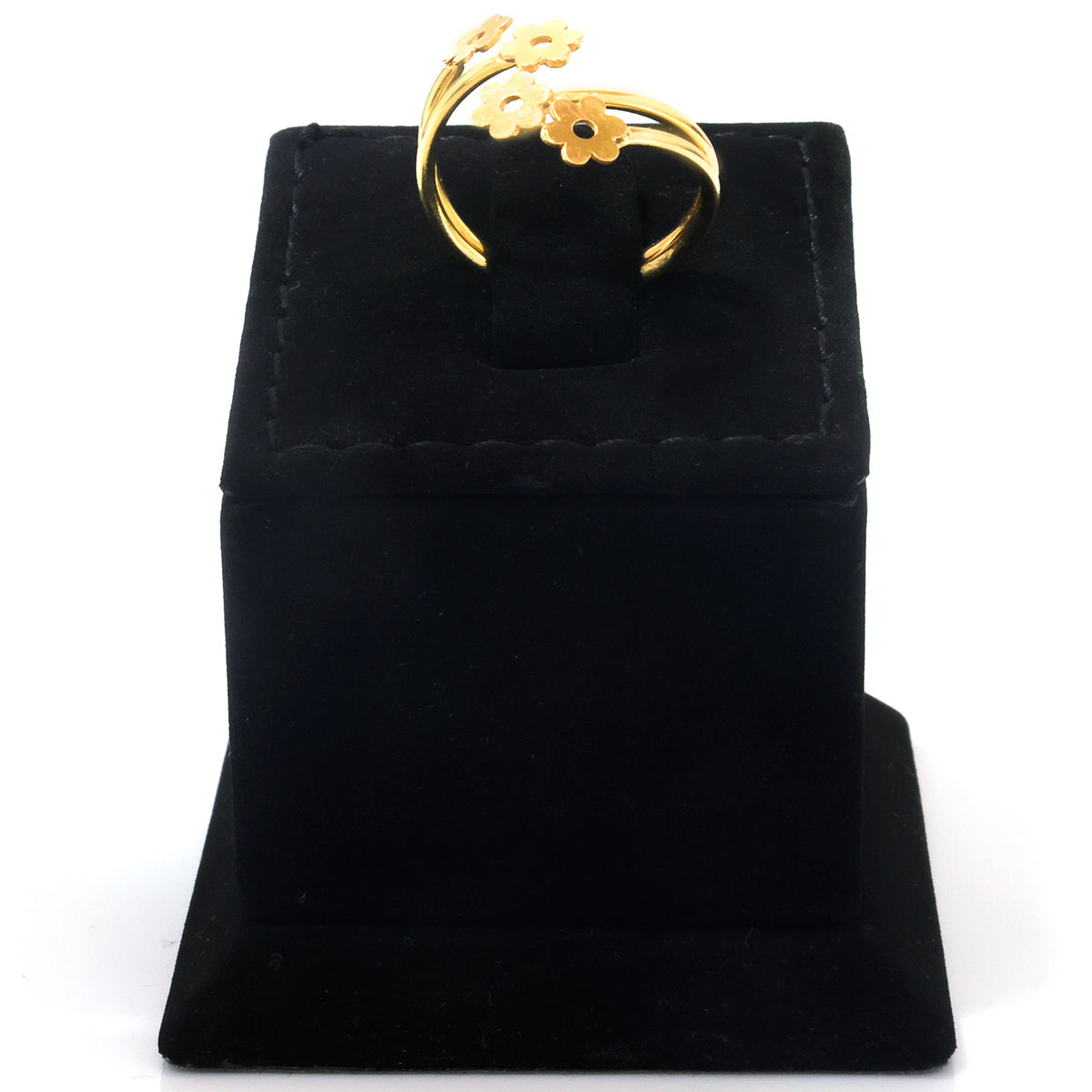 A gold ring with three flower-shaped charms, displayed on a black velvet jewelry box against a white background.