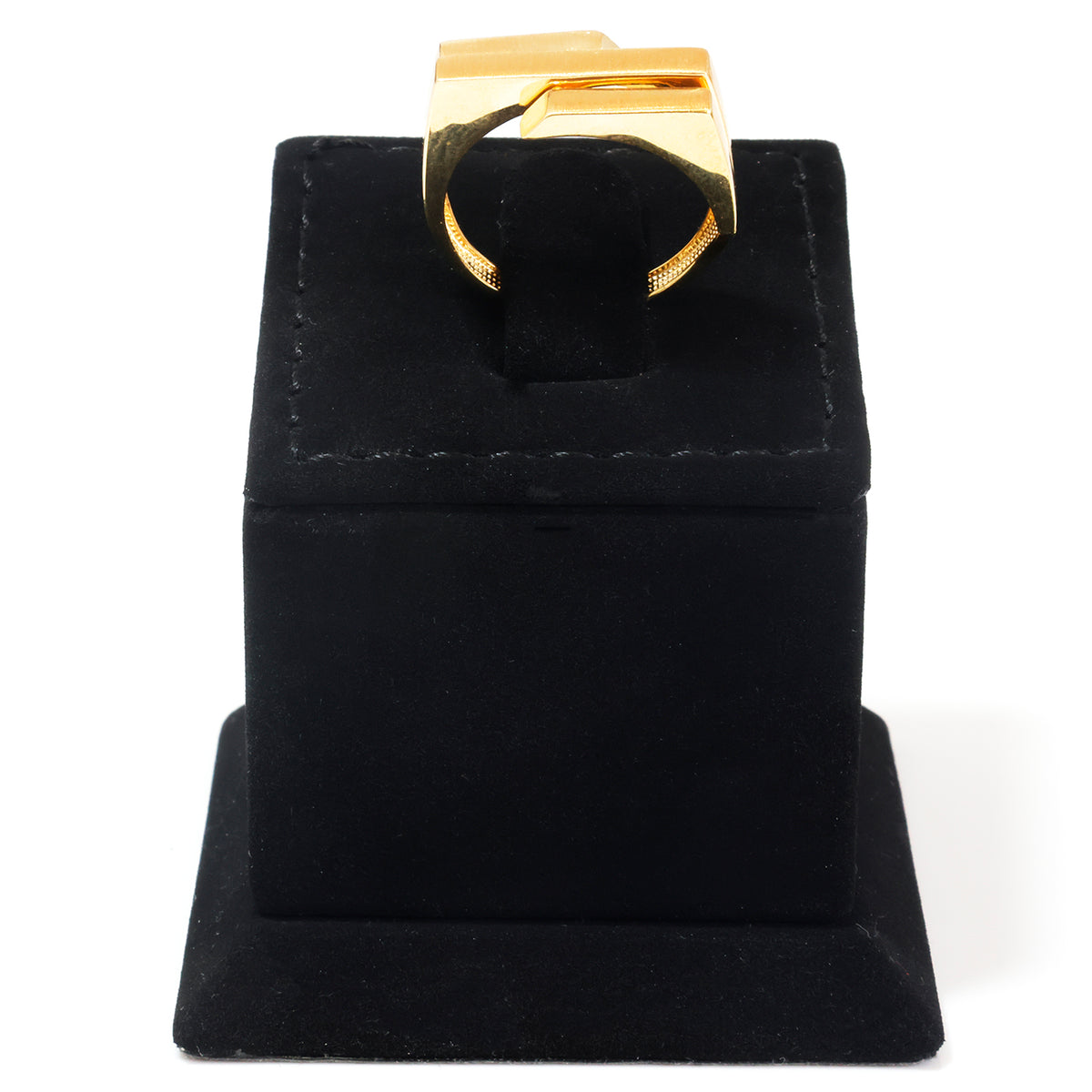 A gold ring displayed on a black velvet jewelry stand against a white background.