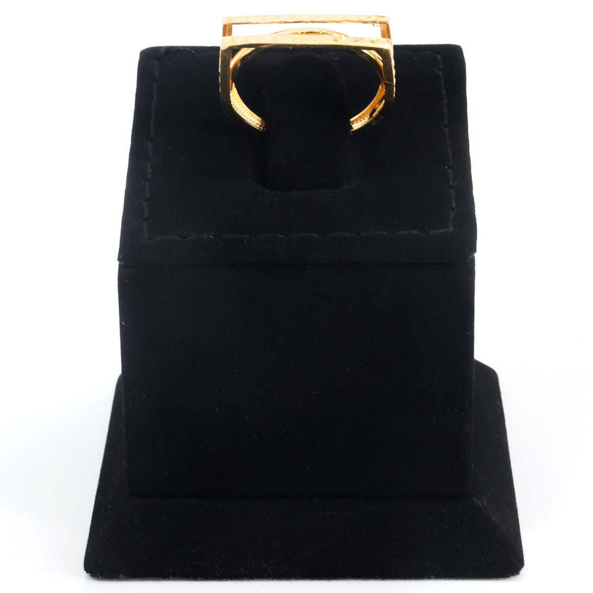 A gold-tone ring displayed on a black velvet ring stand against a plain white background.