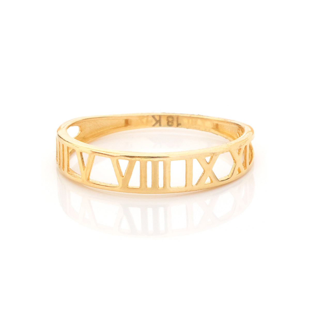 A gold ring featuring open Roman numerals, displayed on a clean white background with a soft reflection underneath.