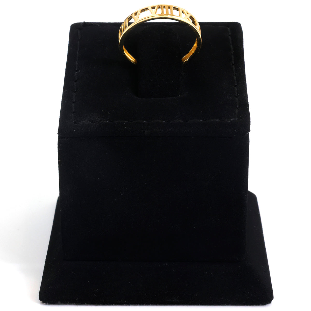 A gold ring with a wide band and openwork geometric pattern, displayed on a black velvet jewelry stand against a white background.