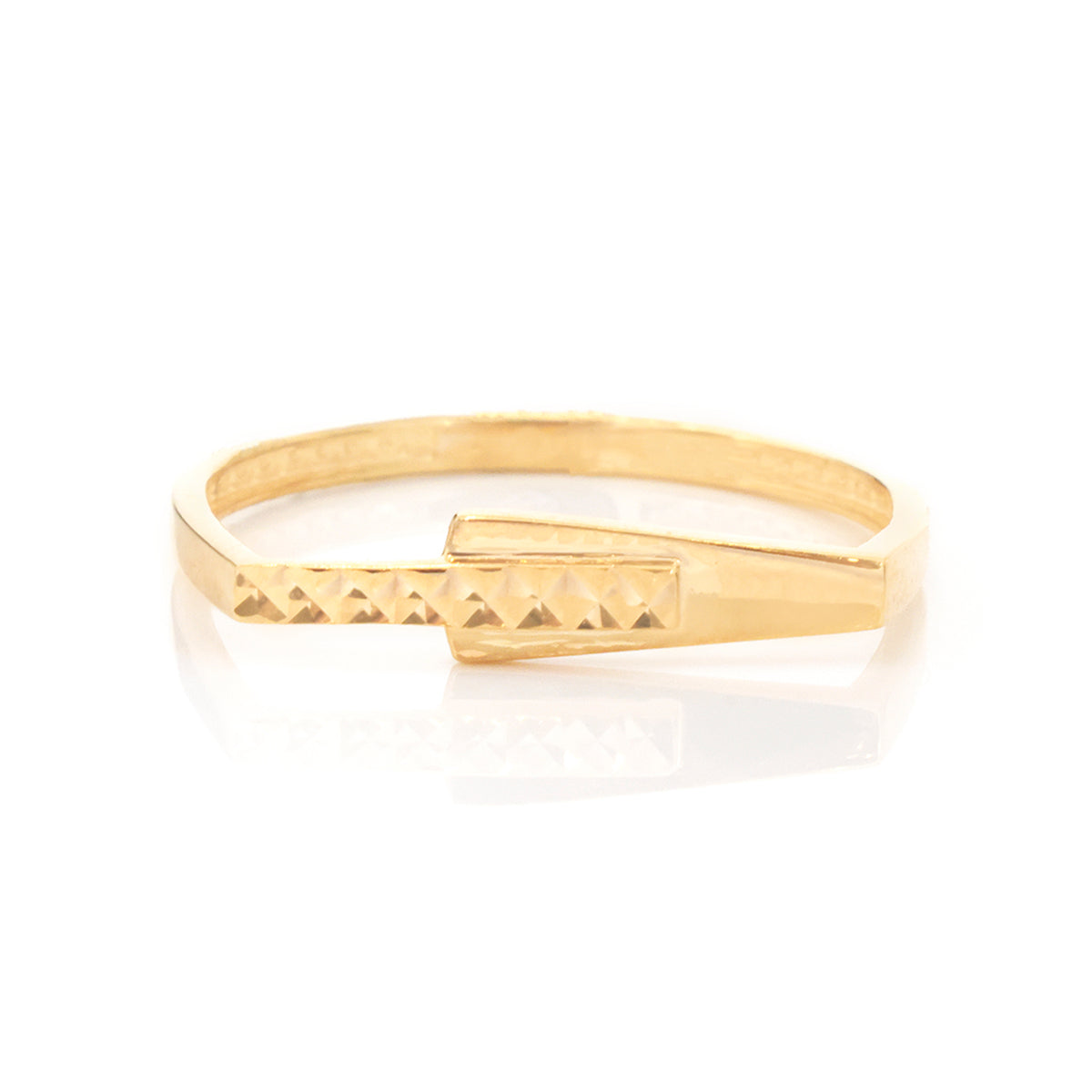 A gold band ring with a textured triangular pattern on the front and a polished rectangular accent, shown on a white reflective background.