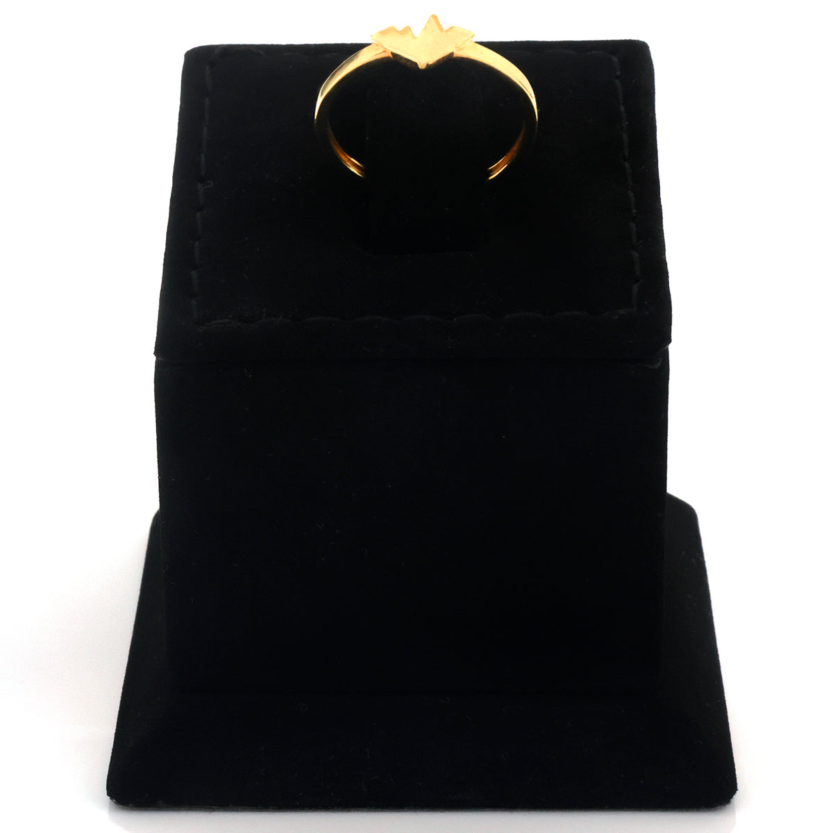 A gold ring with a crown-like top, displayed on a black velvet ring box against a white background.