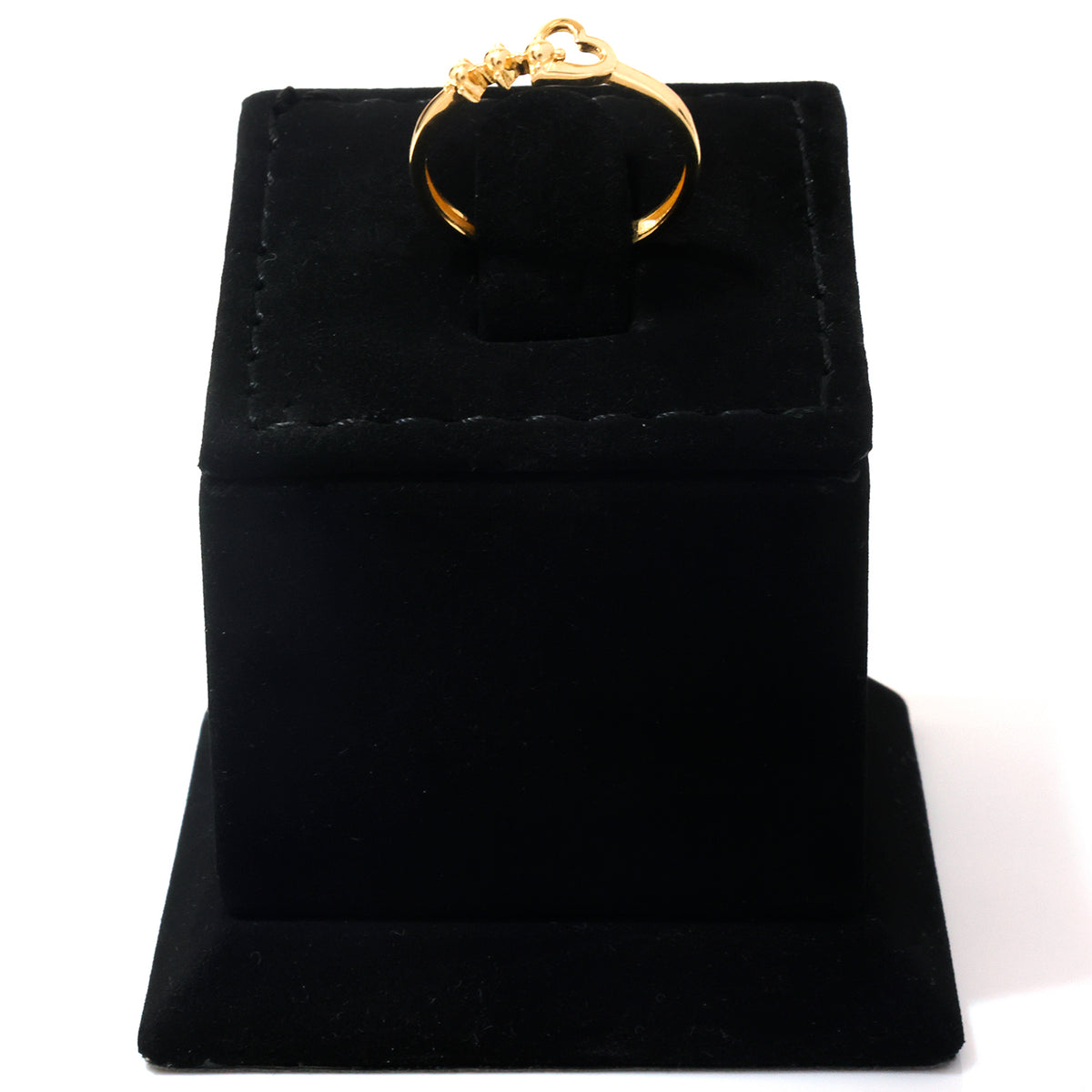 A gold ring displayed on a black velvet ring box against a white background.