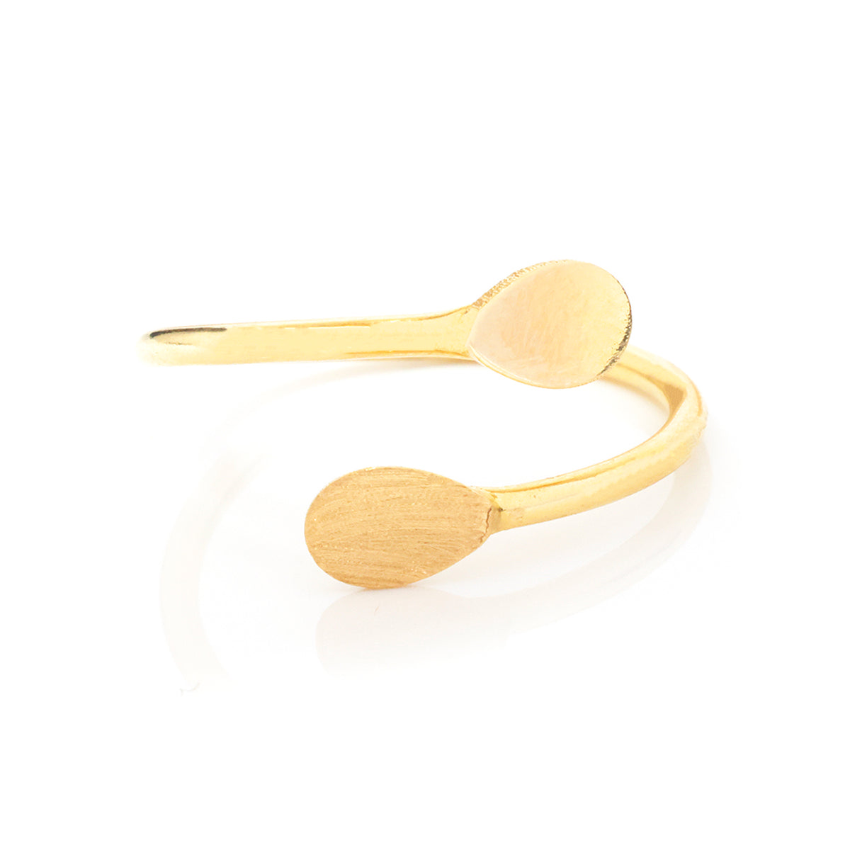 A minimalist gold open cuff ring with two flat, oval spoon-like ends, displayed on a clean white background with a soft reflection.