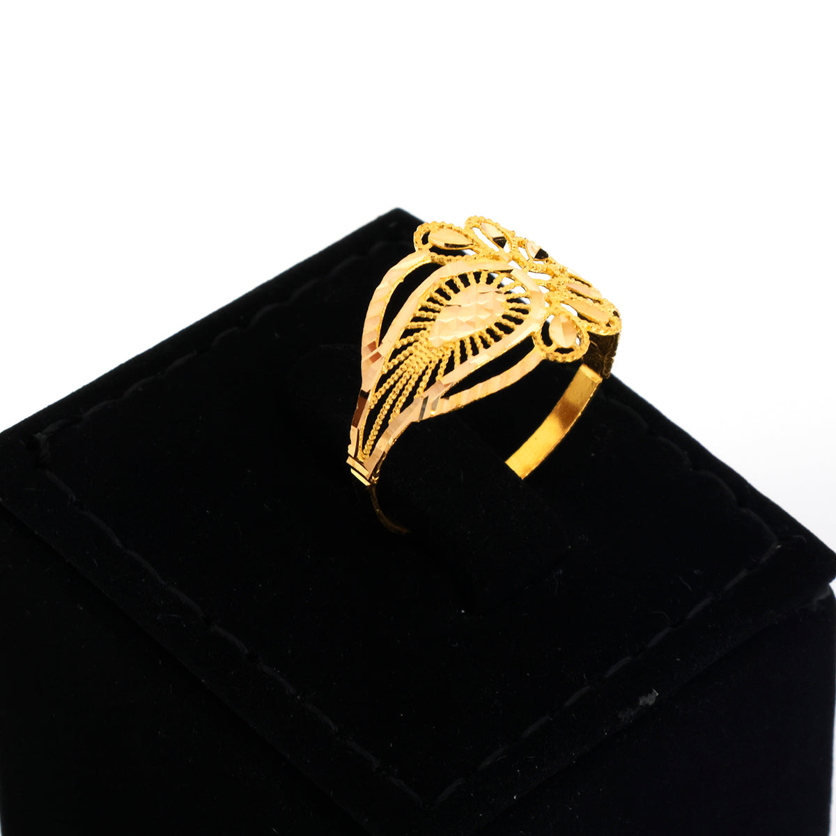 A gold filigree ring with a sunburst center and leaf-like patterns, displayed on a black velvet jewelry box against a white background.