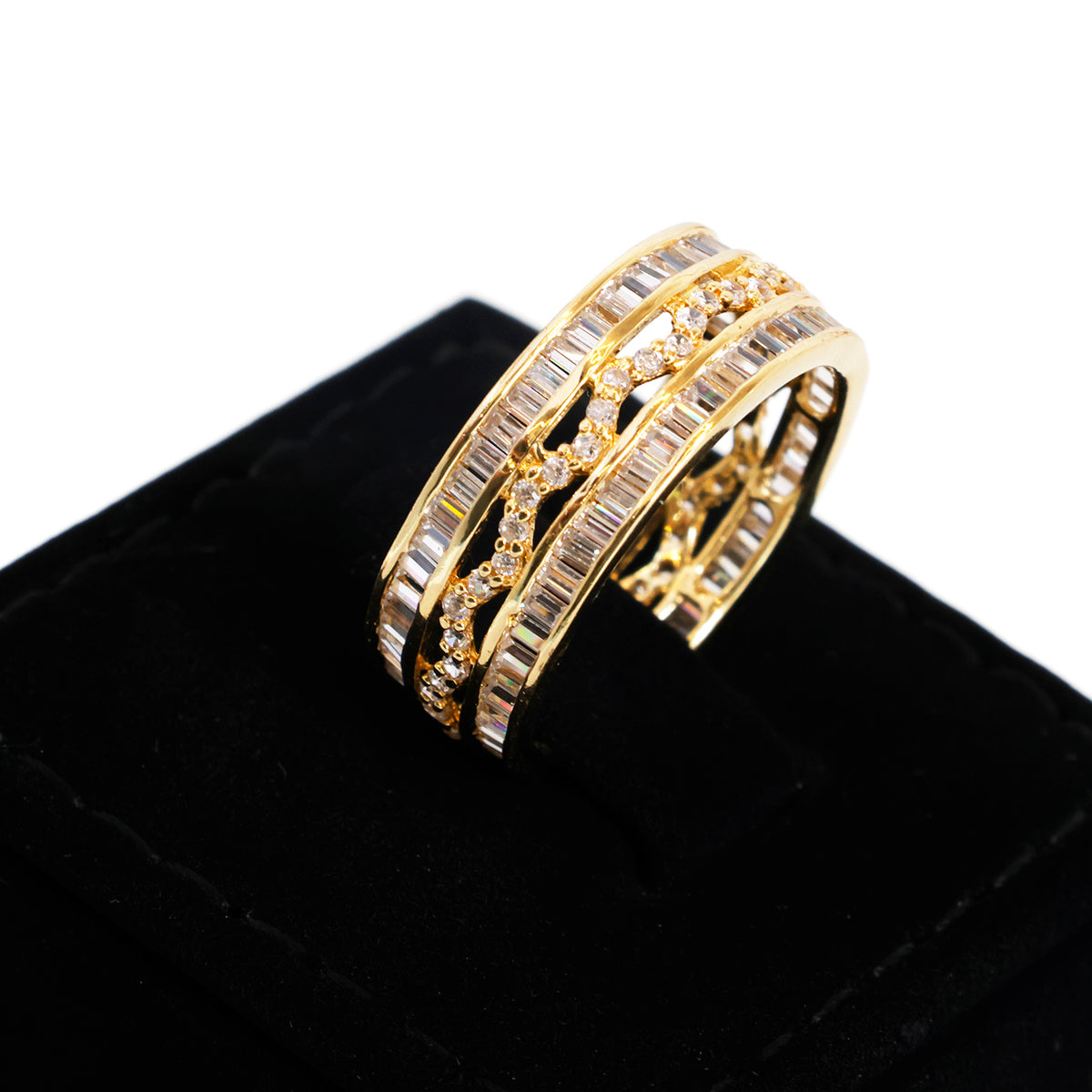 A gold double-band ring with baguette and round-cut stones, displayed on a black velvet ring box against a white background.