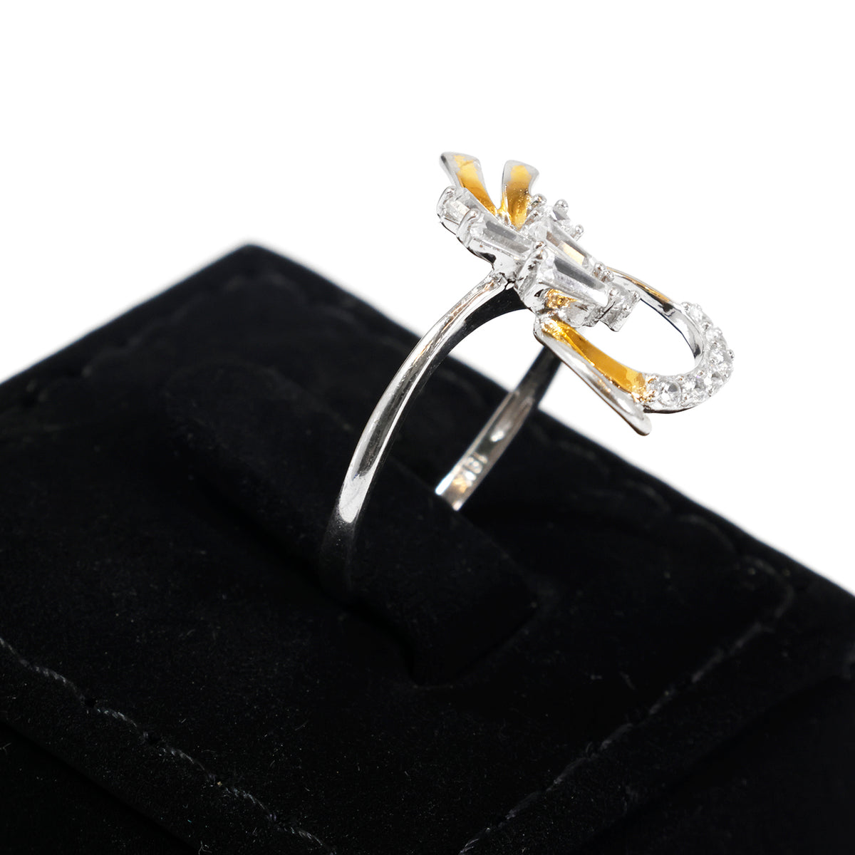 A silver and yellow gold ring displayed on a black velvet ring box against a white background.