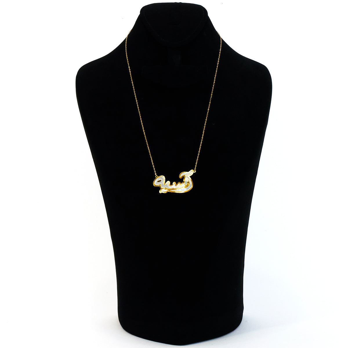 Gold necklace on a black mannequin bust against a white background