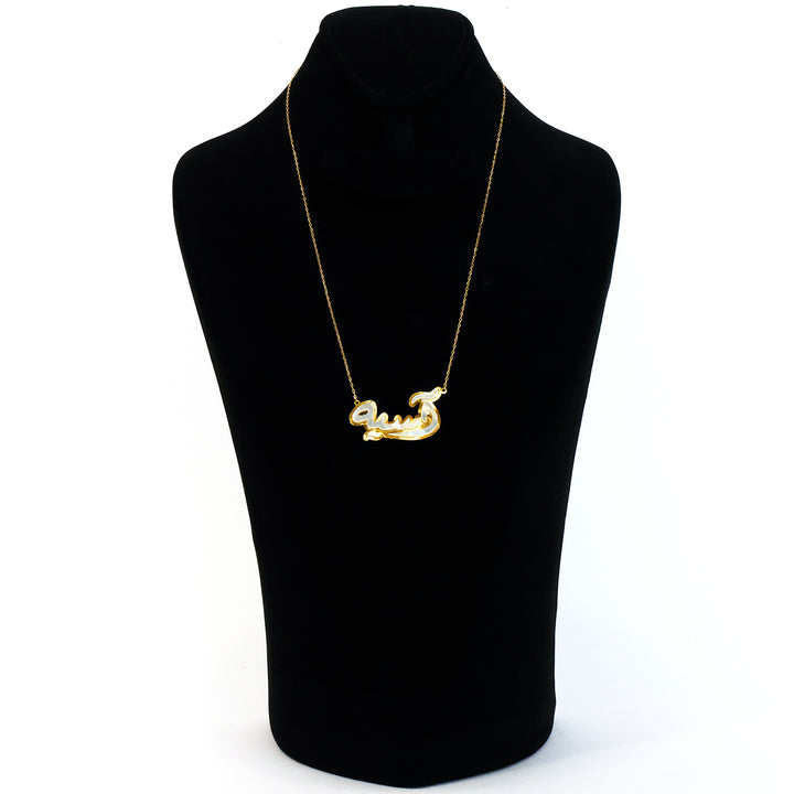 Gold necklace on a black mannequin bust against a white background