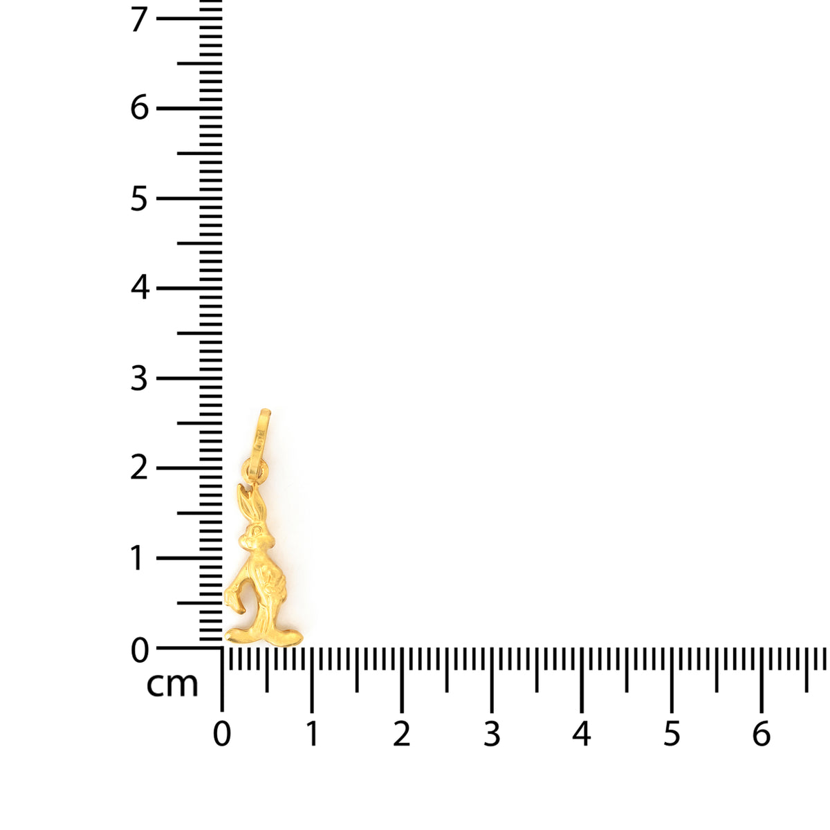 Gold yoga pose pendant next to a ruler on a white background