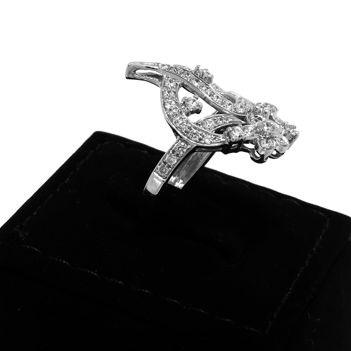 Silver ring with gemstones on a black velvet cushion