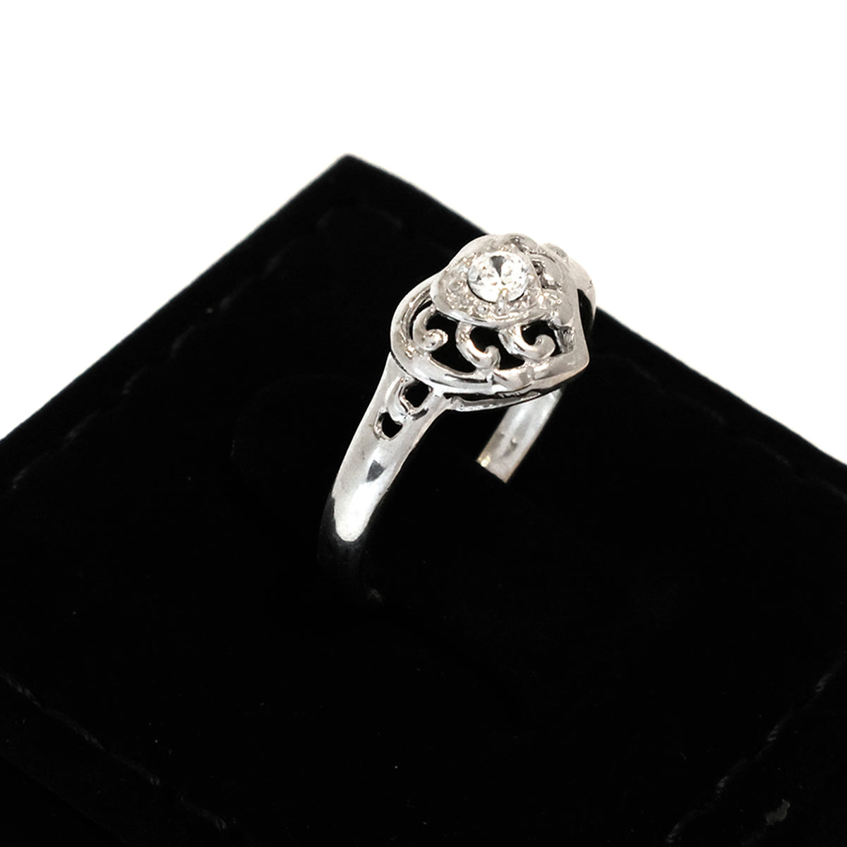 Silver ring with a diamond on a black velvet cushion