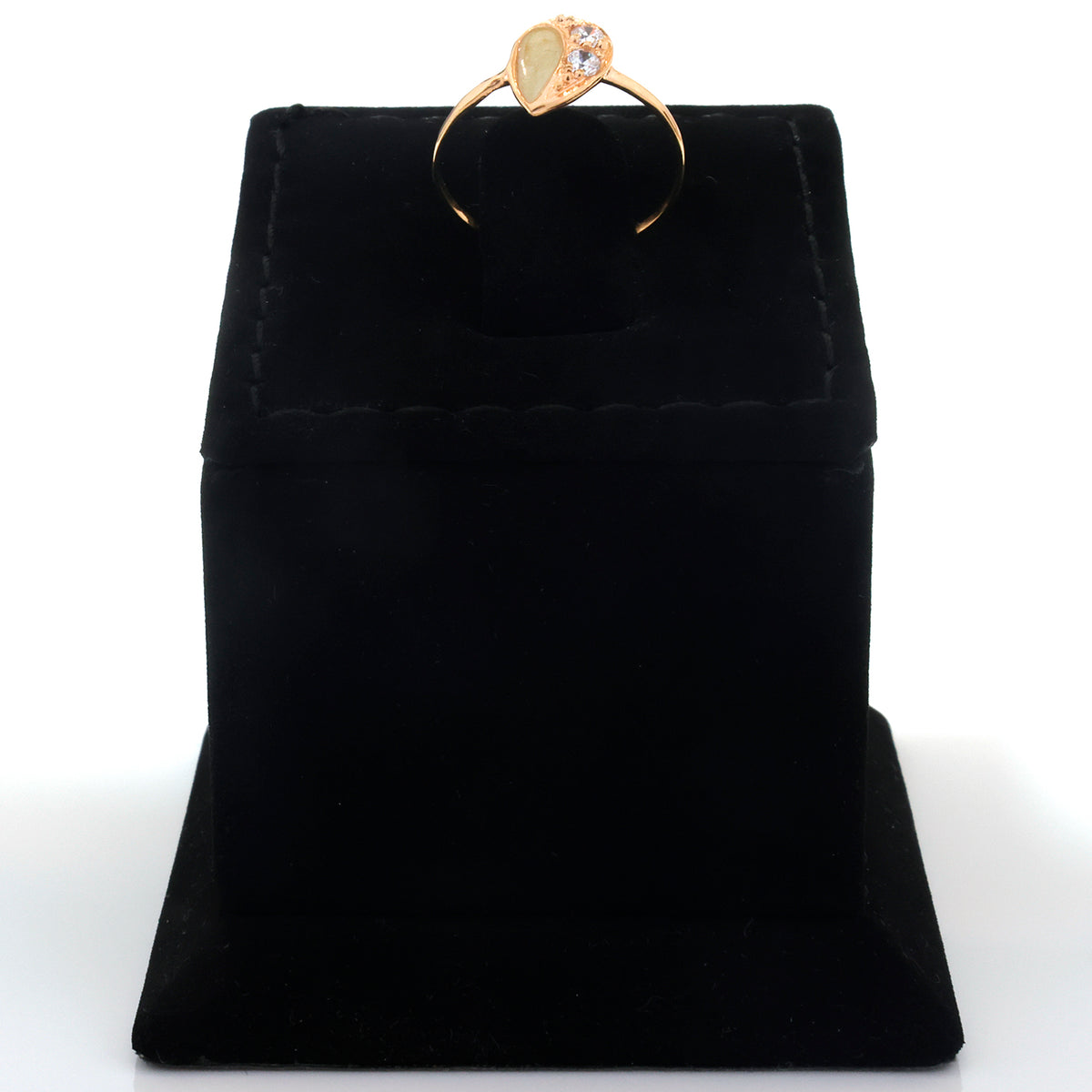 A gold ring with a heart-shaped clear gemstone displayed on a black velvet ring box against a white background.