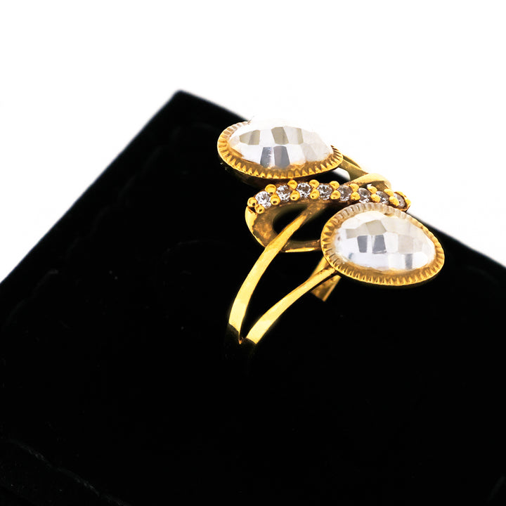 Gold brooch with clear gemstones on a black background