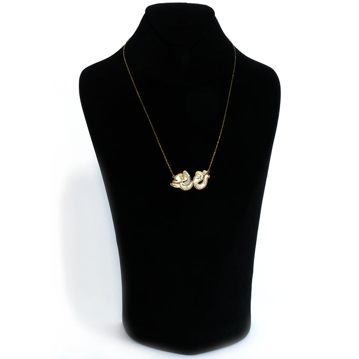 Gold necklace on a black mannequin bust against a white background
