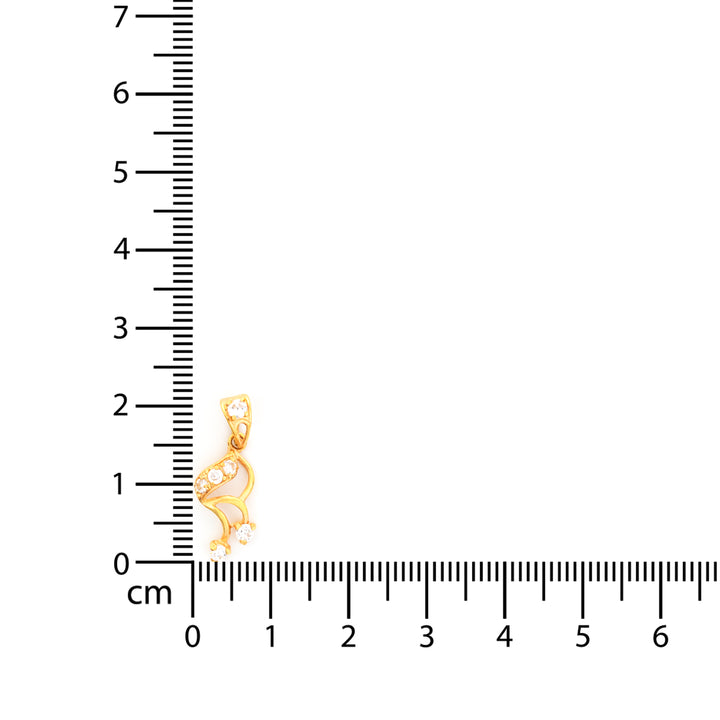 Gold pendant next to a ruler on a white background