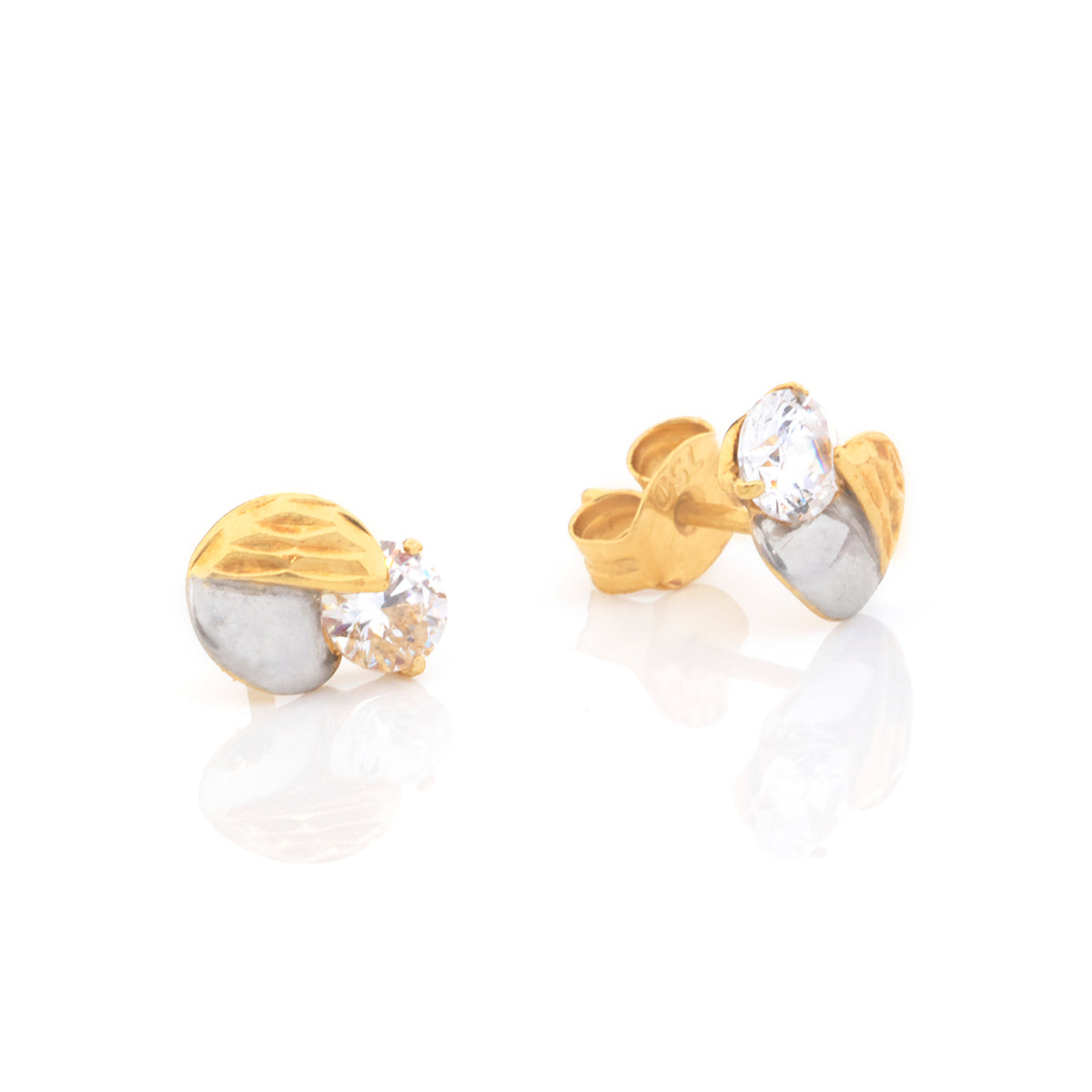 A pair of gold and silver stud earrings with clear oval gemstones, shown on a reflective white surface against a white background.