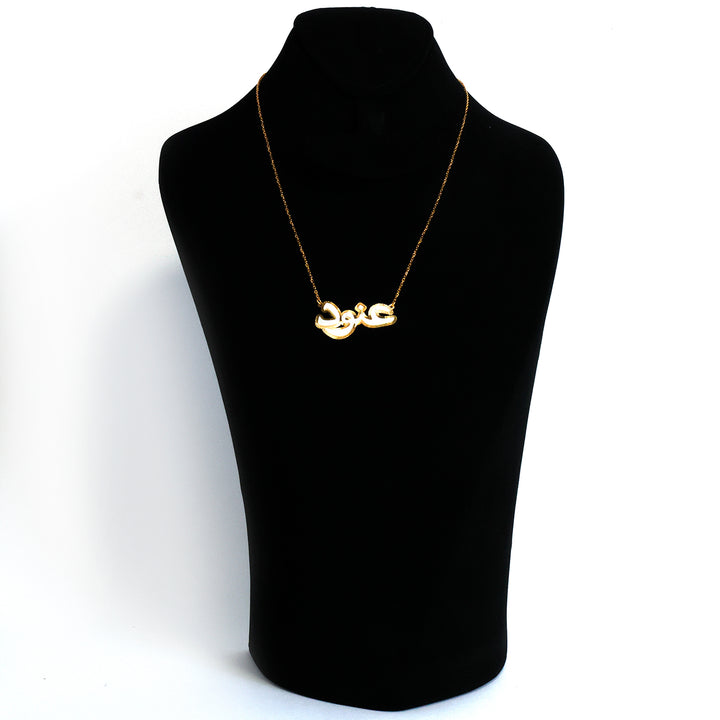 Gold necklace on a black mannequin bust against a white background
