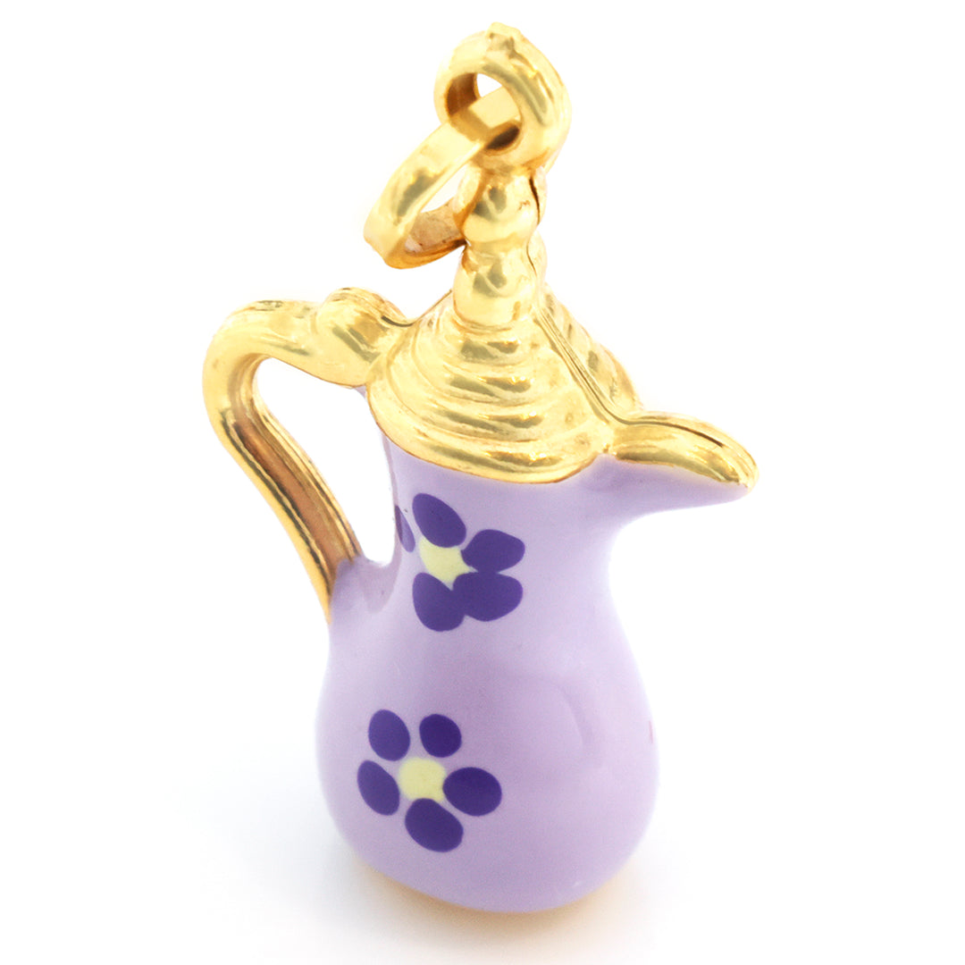 A small decorative teapot charm with a lavender purple body, gold-tone metal top and handle, and purple flower motifs with yellow centers on the front, shown on a white background.