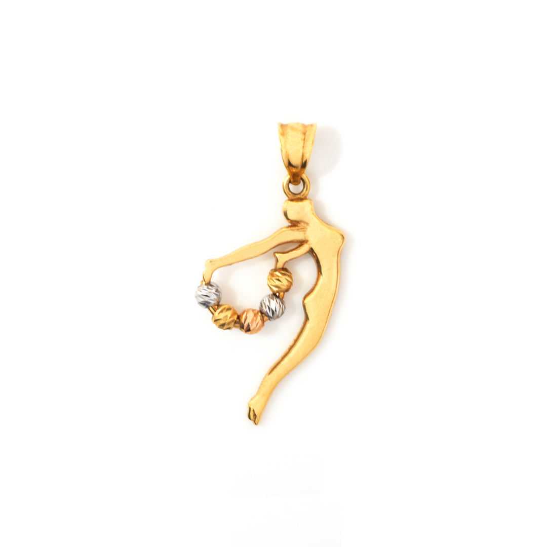 A gold pendant shaped like a stylized dancer or figure holding a small cluster of twisted beads in one hand, shown on a plain white background.