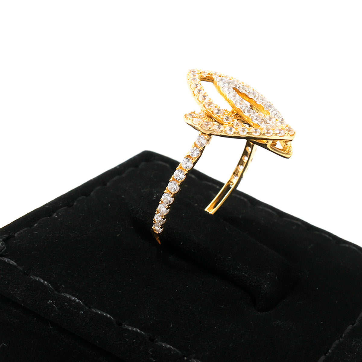 Gold ring with diamond accents on a black cushion against a white background