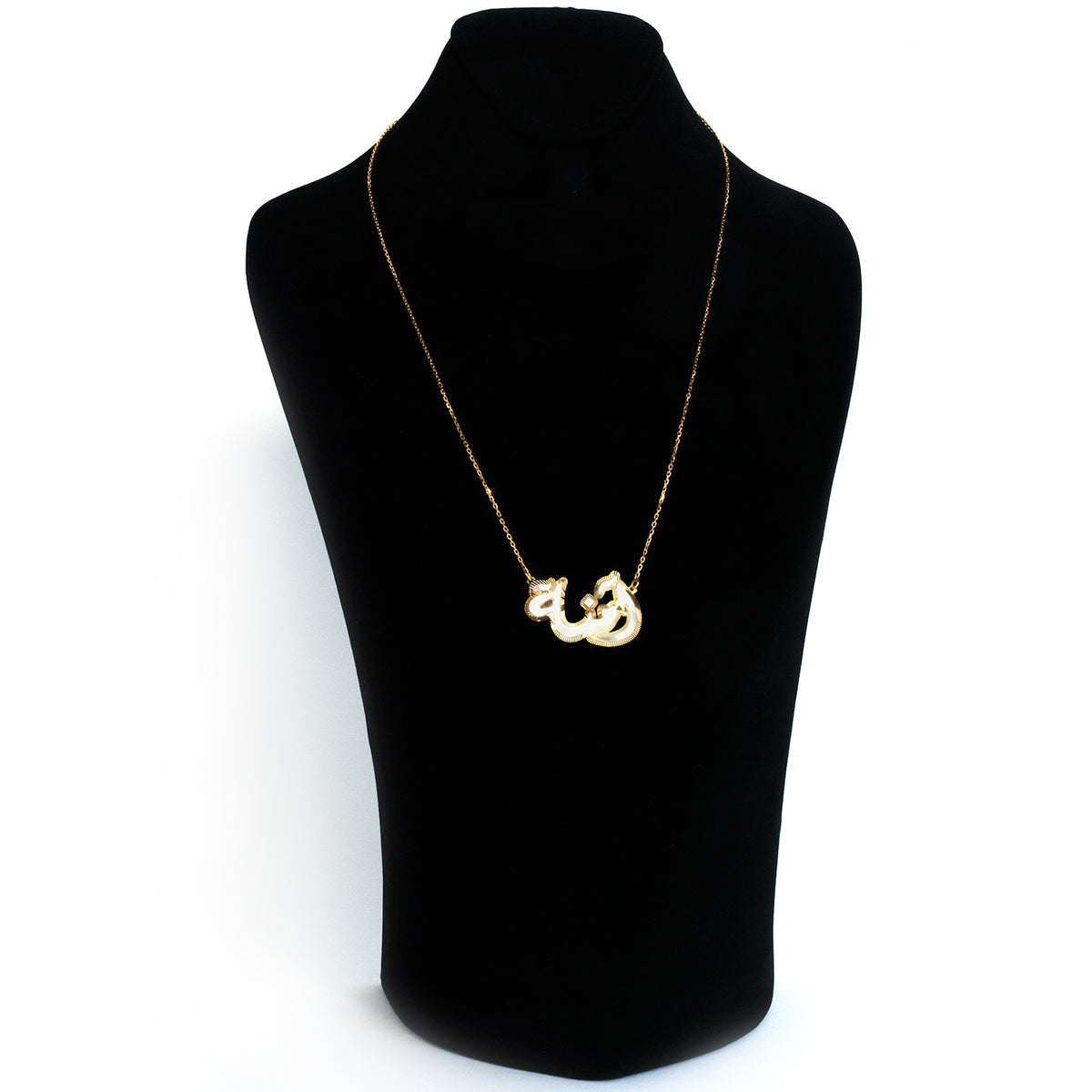Gold necklace with a unique pendant on a black mannequin bust against a white background
