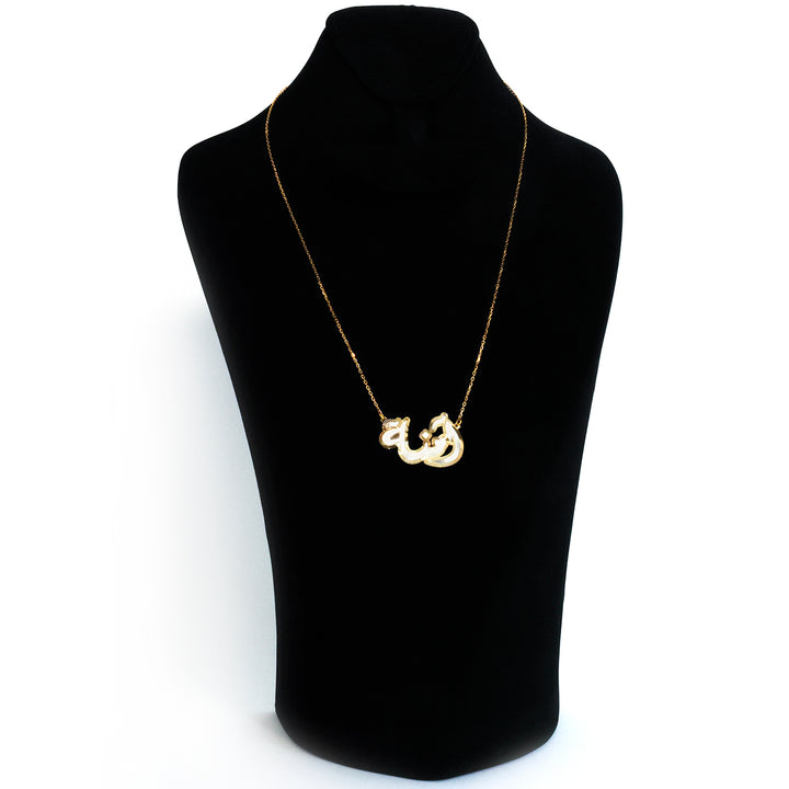 Gold necklace with a unique pendant on a black mannequin bust against a white background