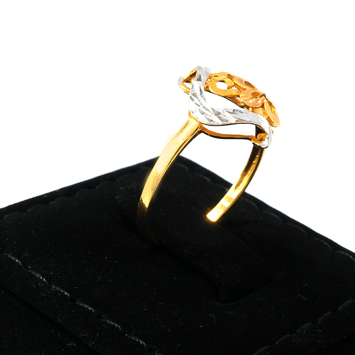 Two-tone gold and silver ring on a black velvet cushion with a white background