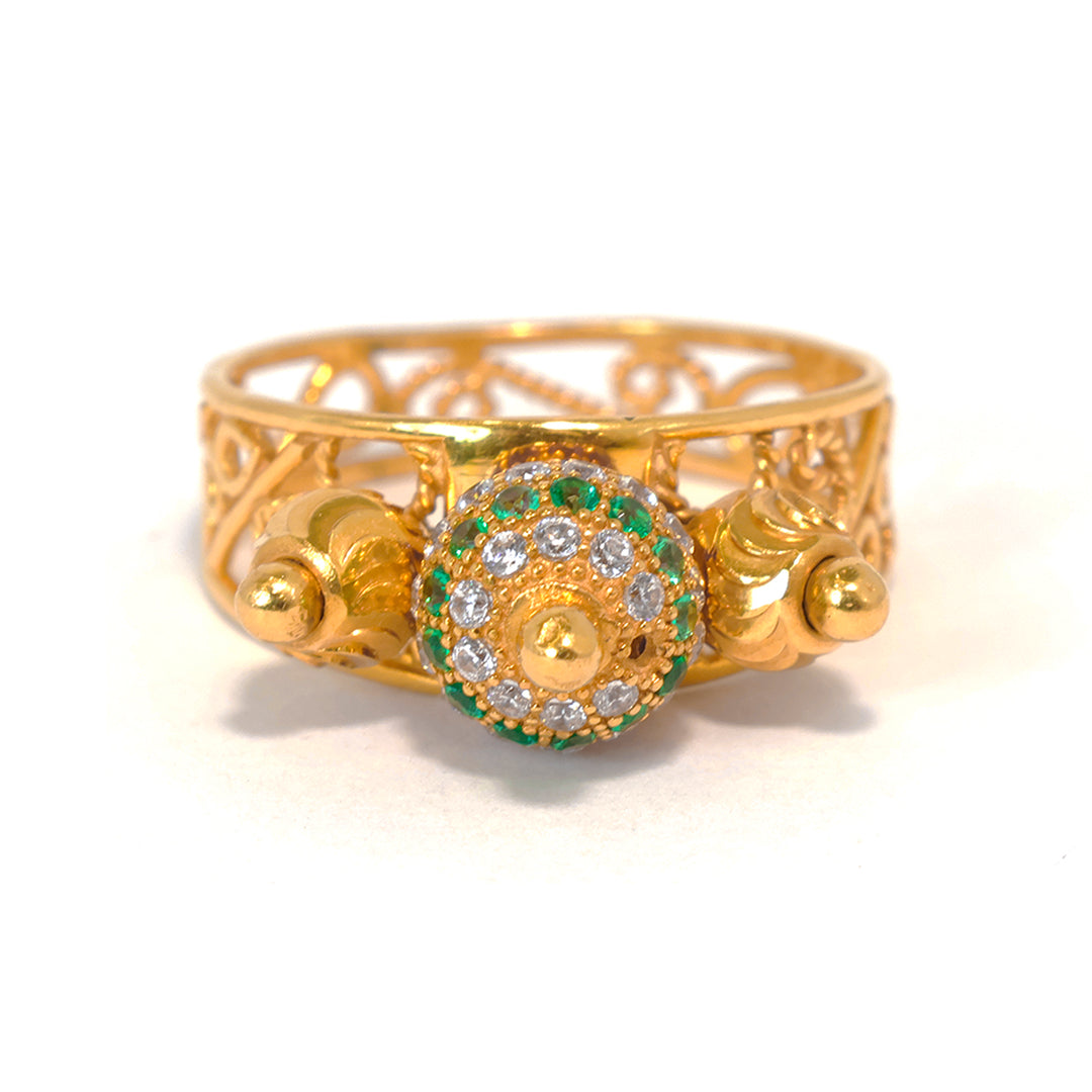 Gold ring with decorative design and gemstones on a white background