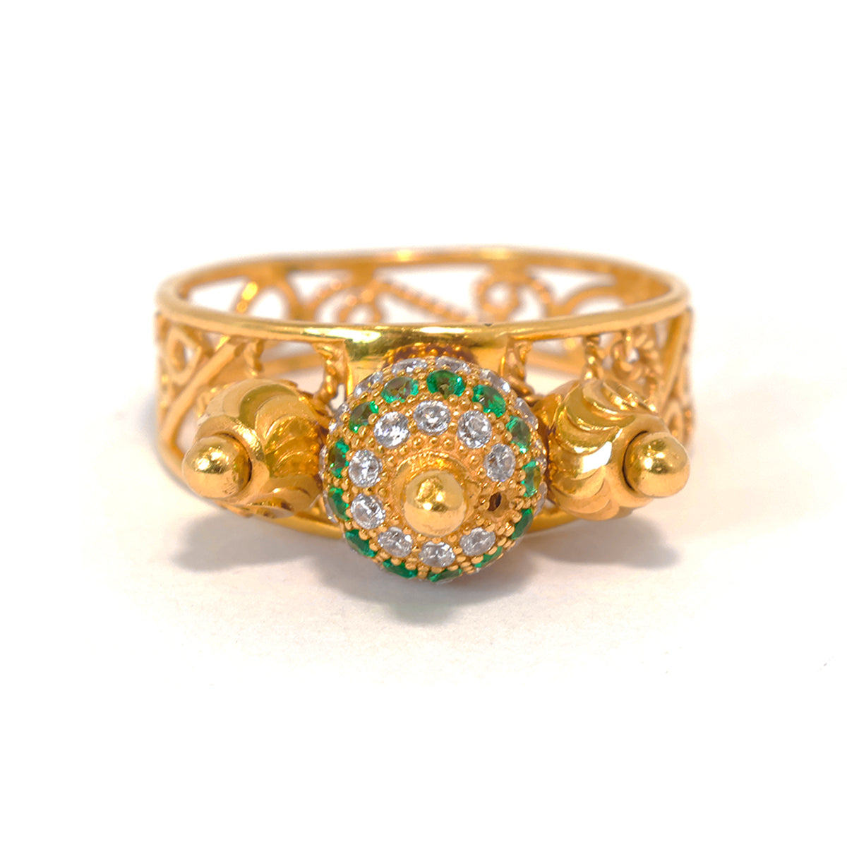 Gold ring with decorative design and gemstones on a white background