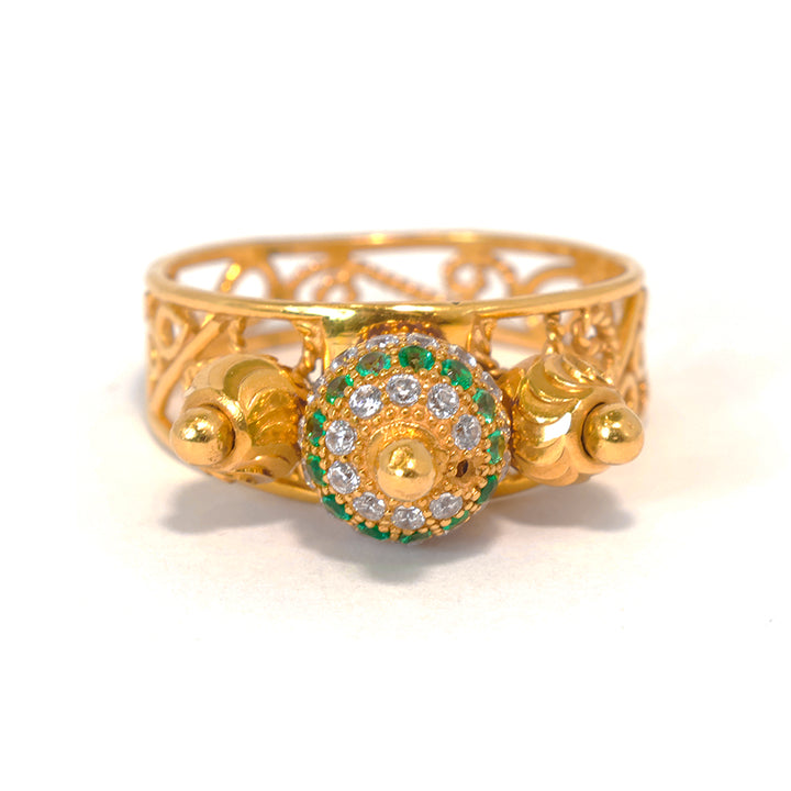 Gold ring with decorative design and gemstones on a white background