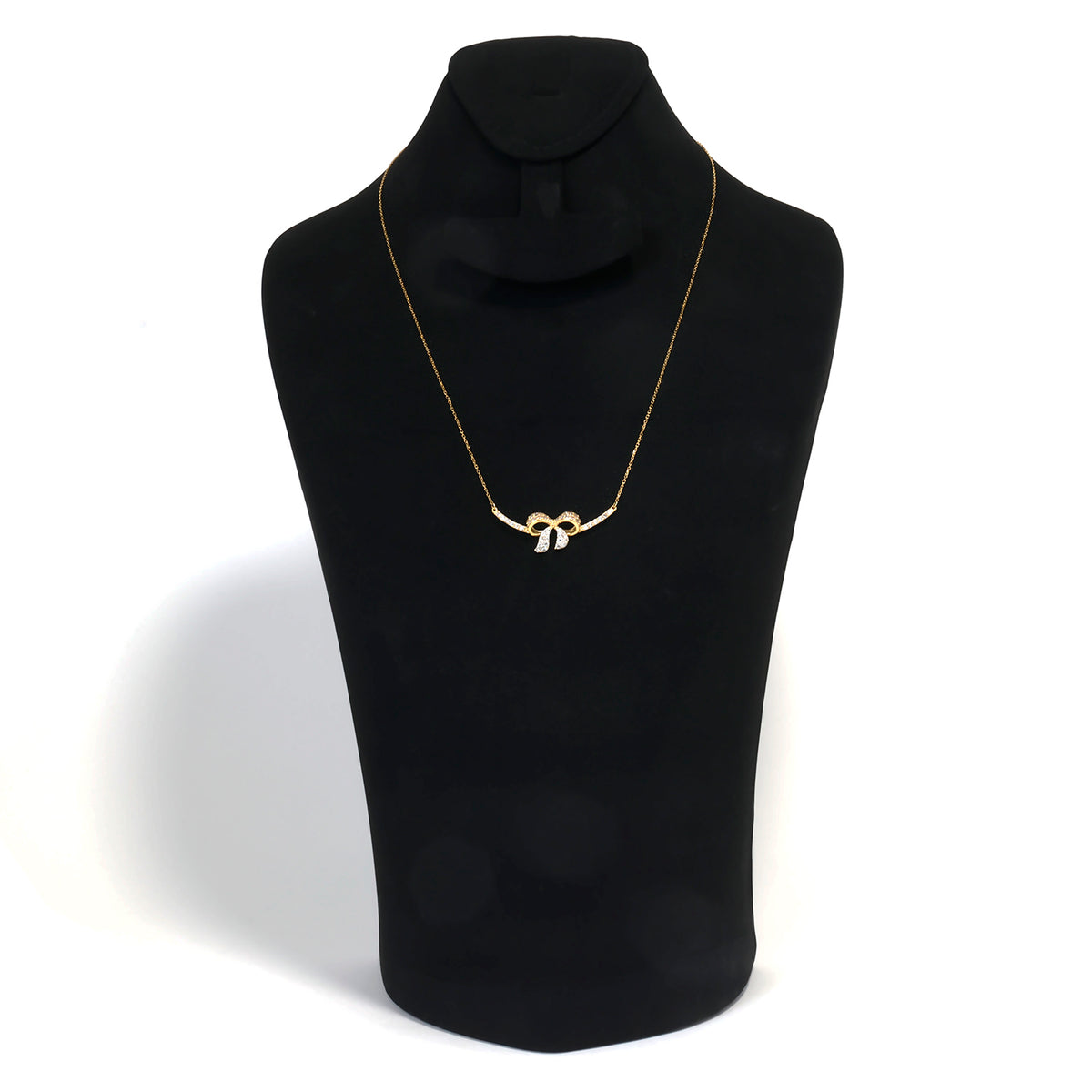 Gold necklace on a black mannequin bust against a white background