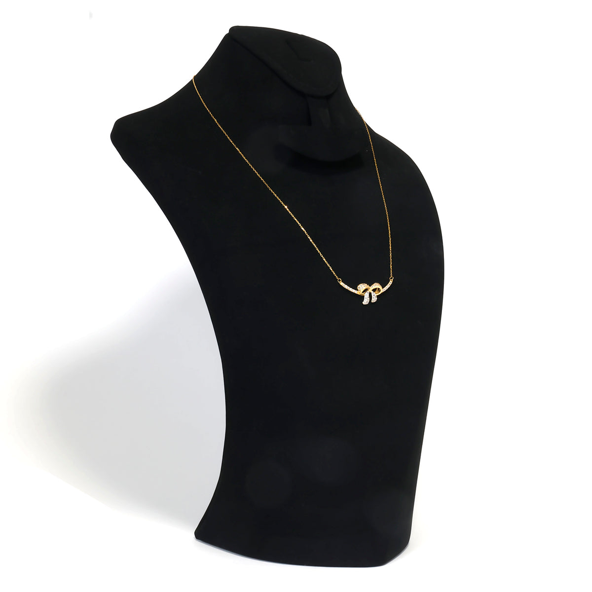 Gold necklace on a black mannequin bust against a white background