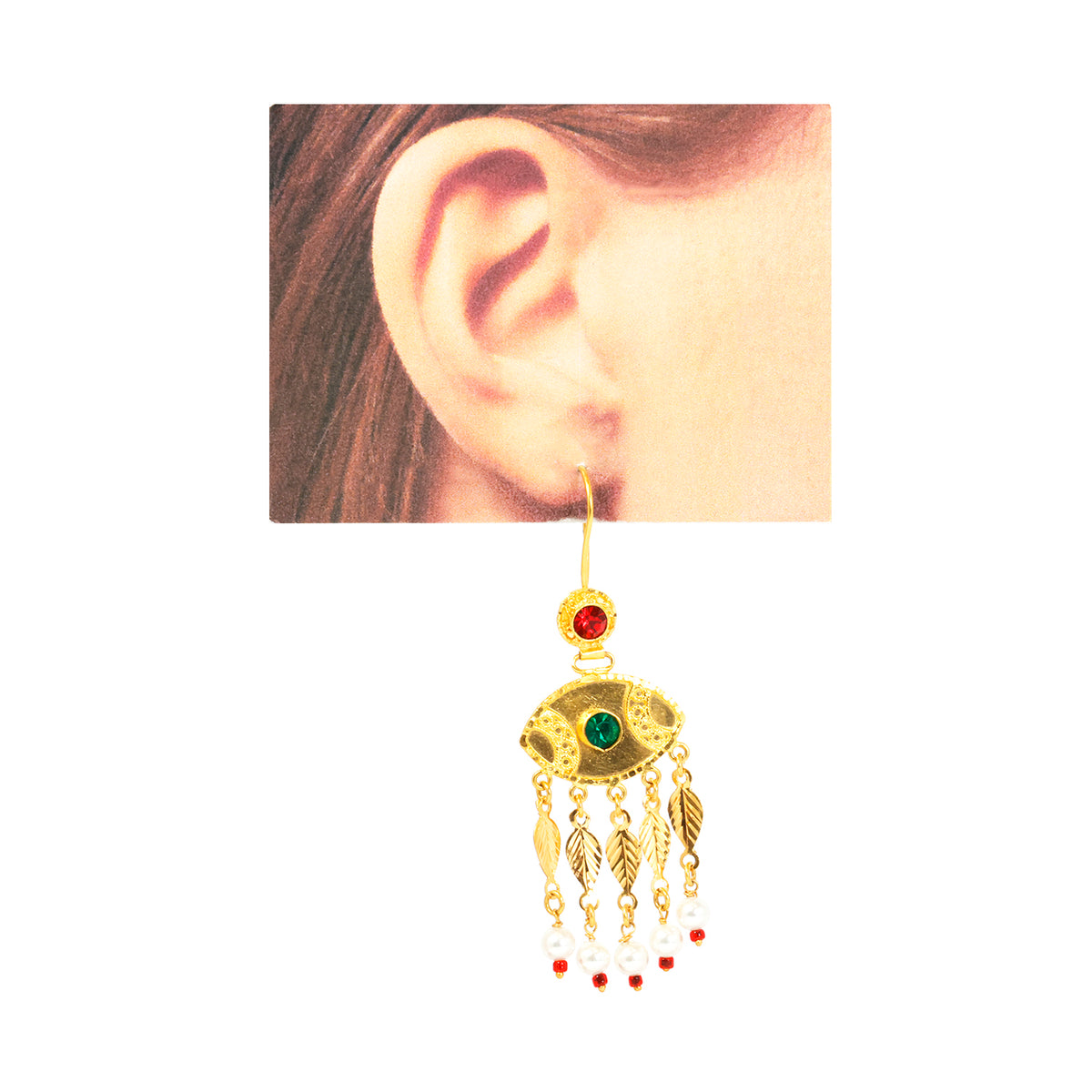 Gold earring with green gemstone worn on an ear against a white background