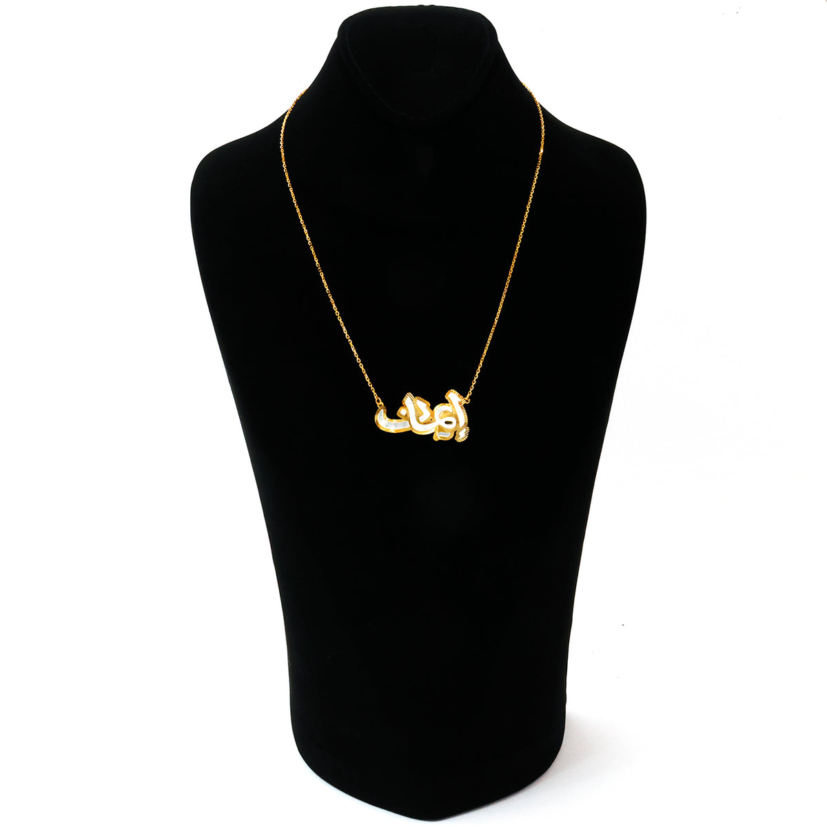 Silver necklace on a black mannequin bust against a white background