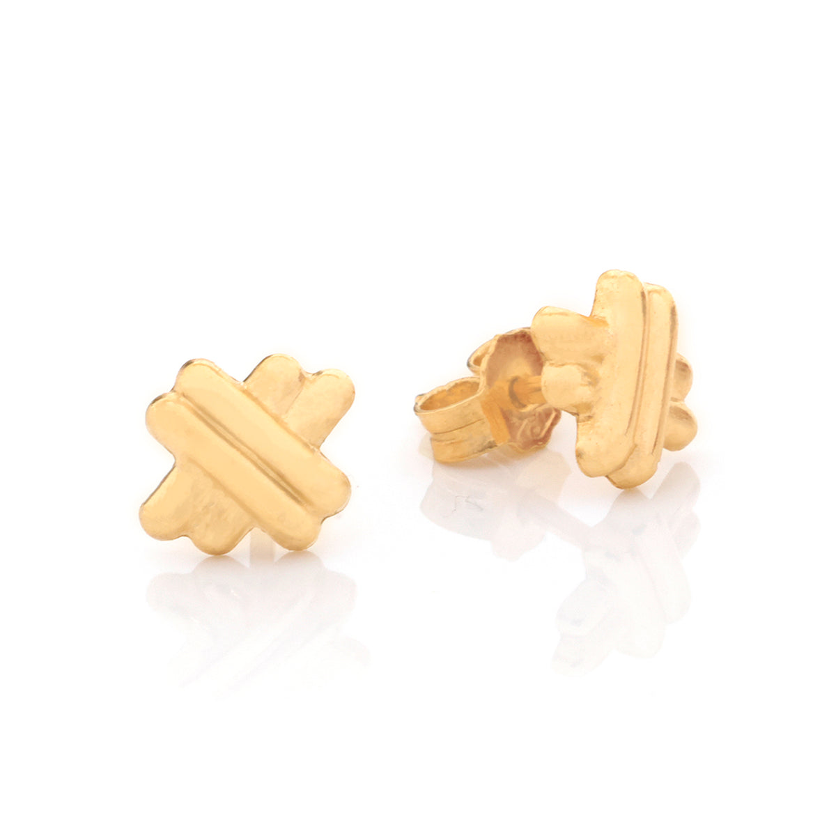 A pair of gold stud earrings with a textured, geometric cross-like design, displayed on a clean white reflective surface.