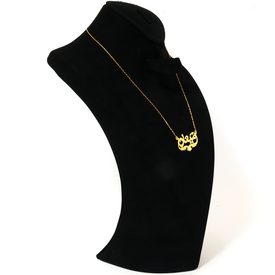 Gold necklace on a black mannequin bust against a white background