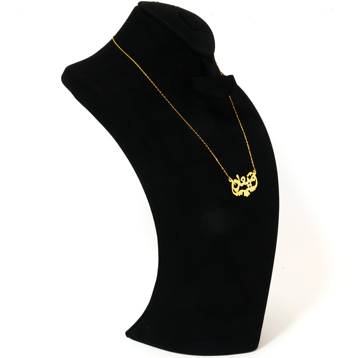 Gold necklace on a black mannequin bust against a white background