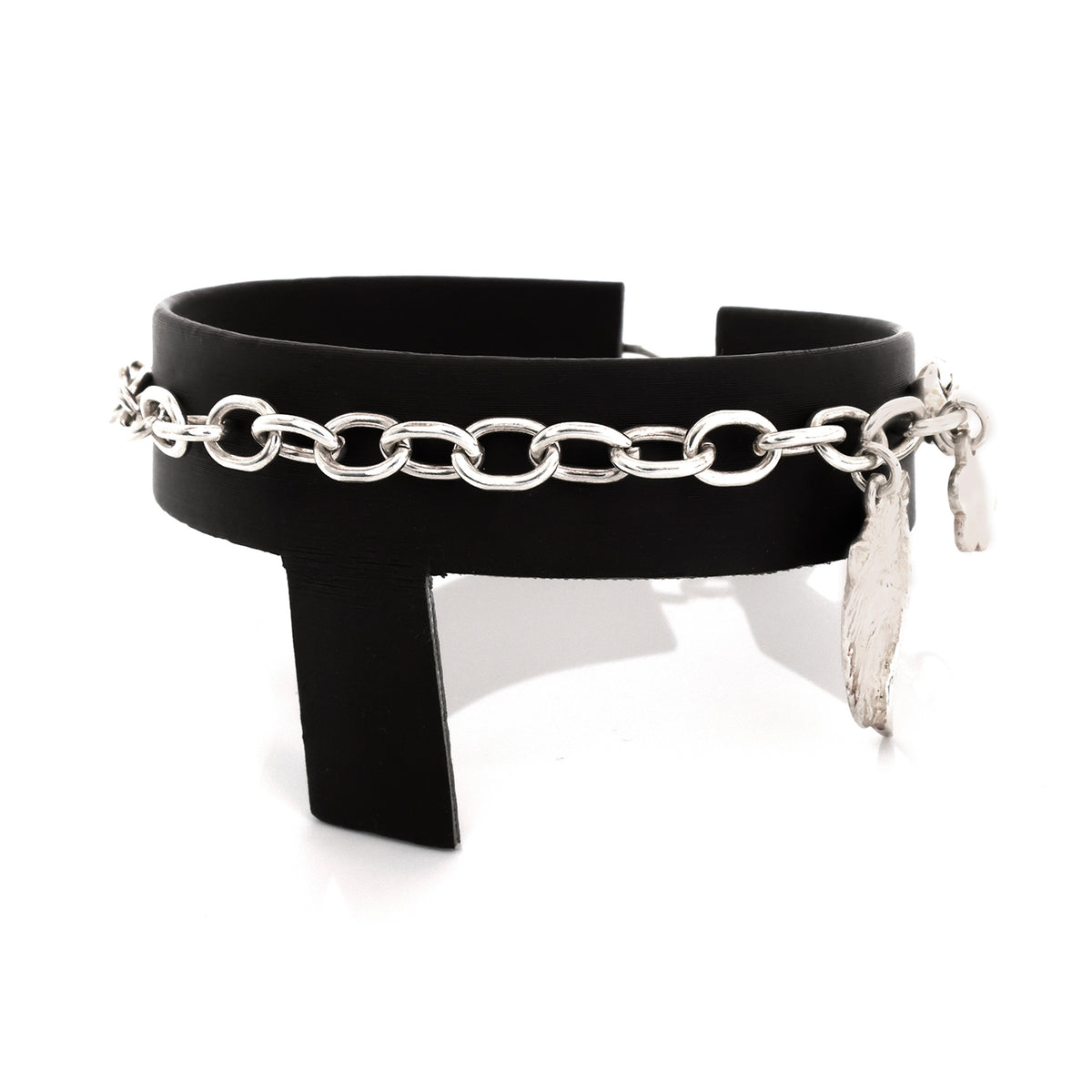 Black leather cuff with silver chain and feather charm on a white background
