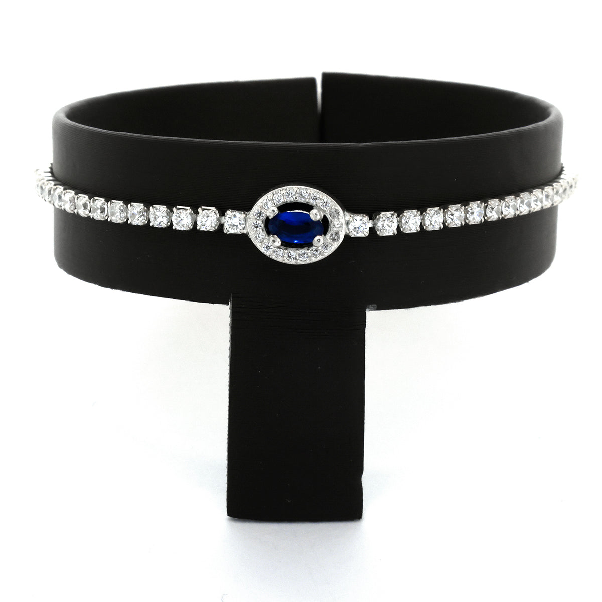 Black choker necklace with a blue gemstone and silver accents on a black stand.