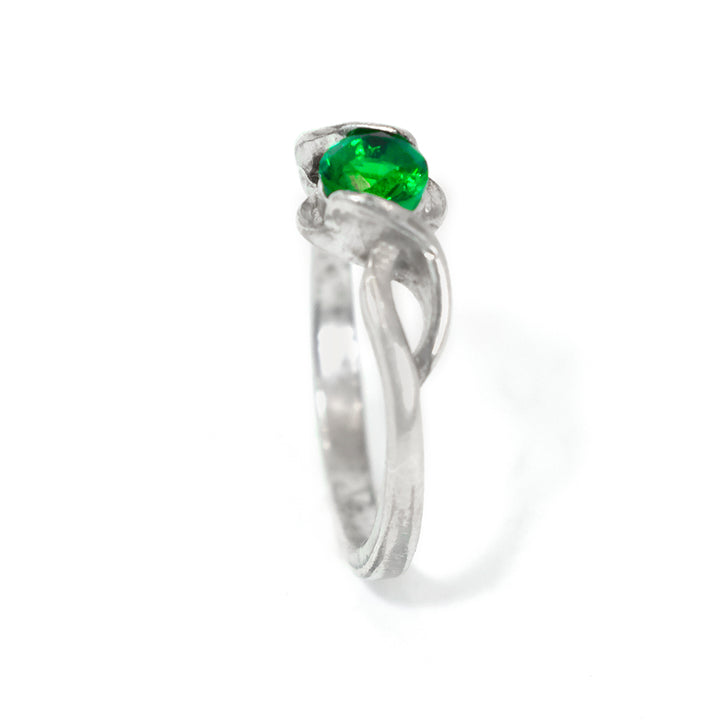 Silver ring with a green gemstone on a white background