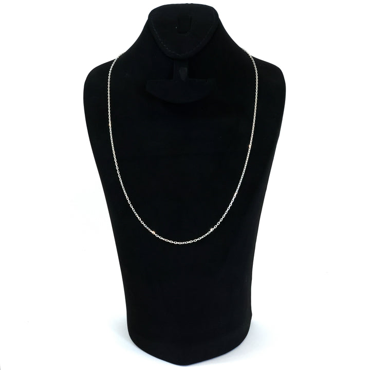Black turtleneck sweater with a silver chain necklace on a mannequin against a white background