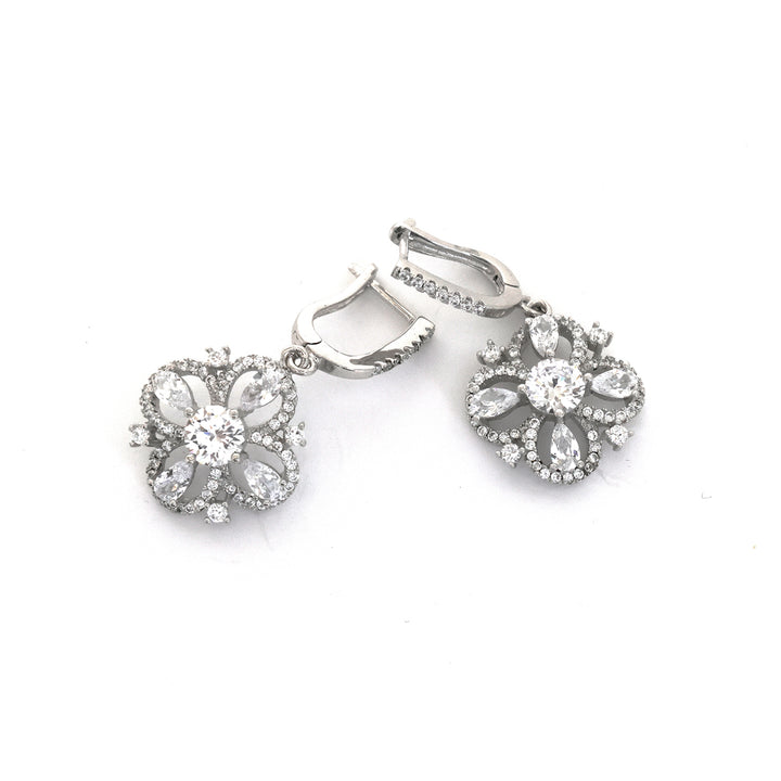 Pair of silver earrings with floral designs on a white background