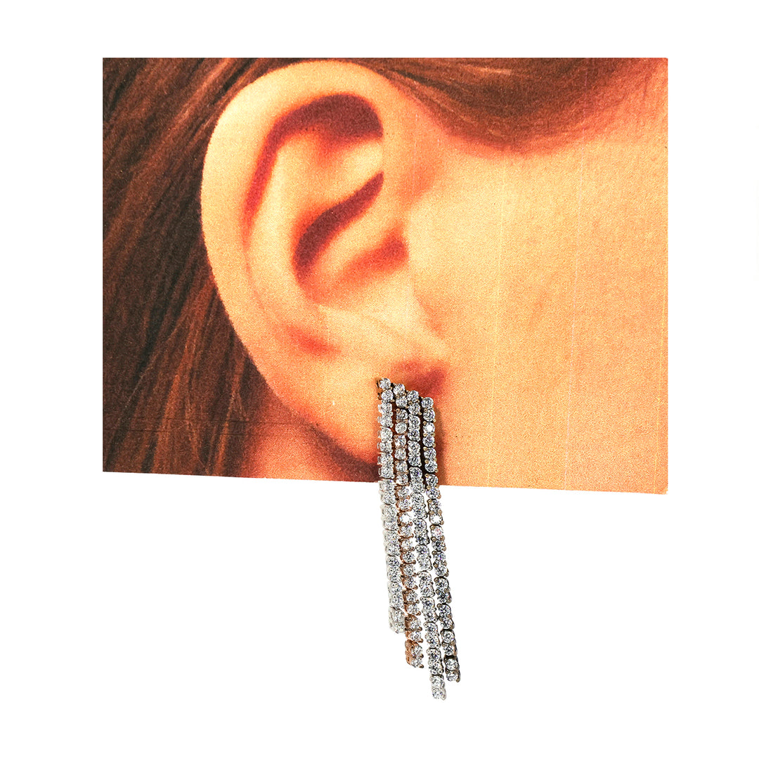 Close-up of an ear wearing a silver earring with a white background