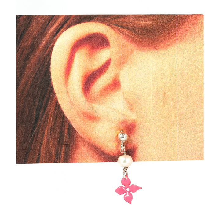 Close-up من ear weaخاتم لؤلؤ قرط مع pink فراشة charm.