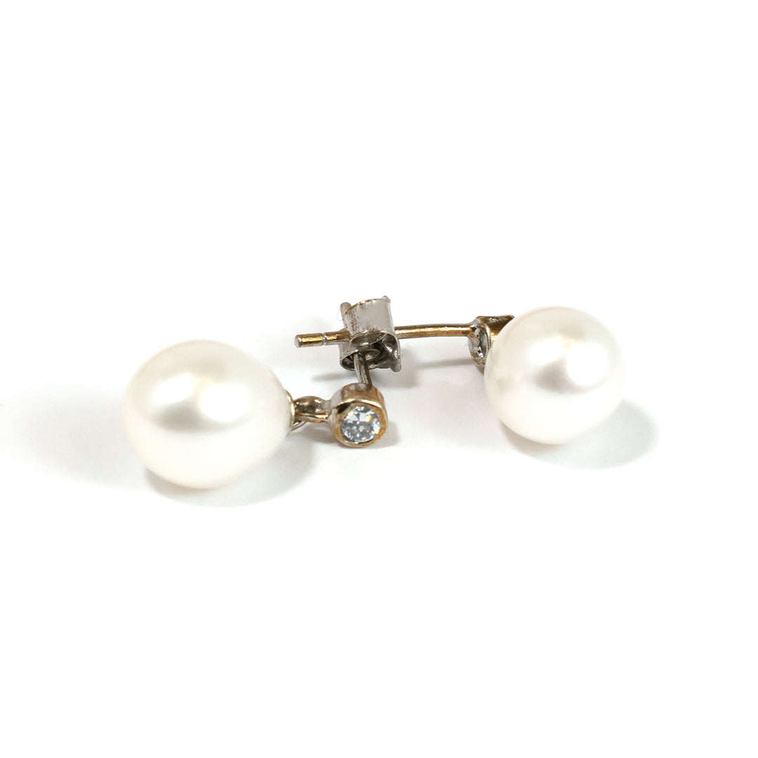 Pearl earrings with a small diamond on a white background